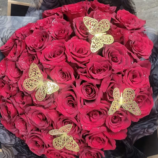 Round bouquet of deep pink roses with gold butterfly accents