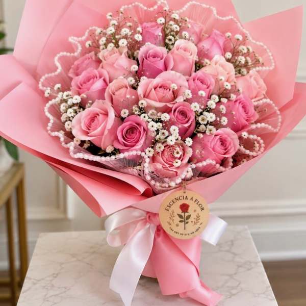 Pink rose bouquet wrapped in pink paper with a white ribbon