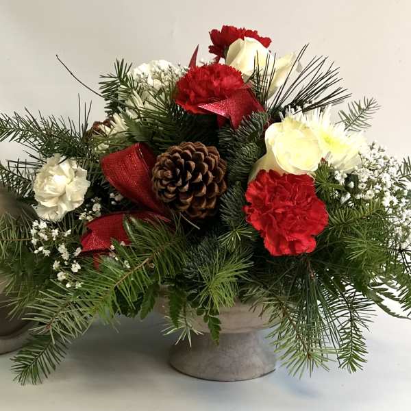Holiday floral arrangement with red and white carnations in a stone vase