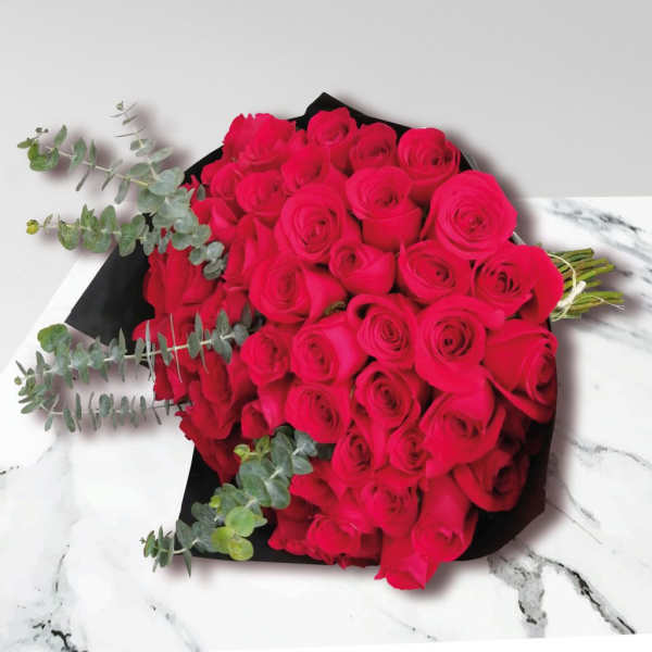 Bouquet of bright pink roses with eucalyptus in black wrap