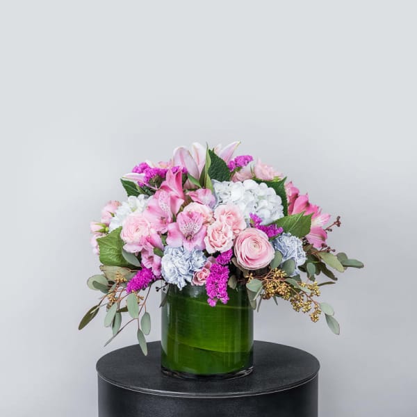 Pink and white mixed bouquet in a green glass vase