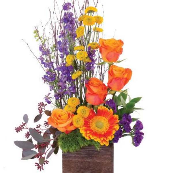 Tall floral arrangement with orange roses, yellow daisies, and purple blooms in a wooden box