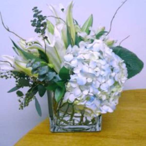 White floral arrangement in a square glass vase