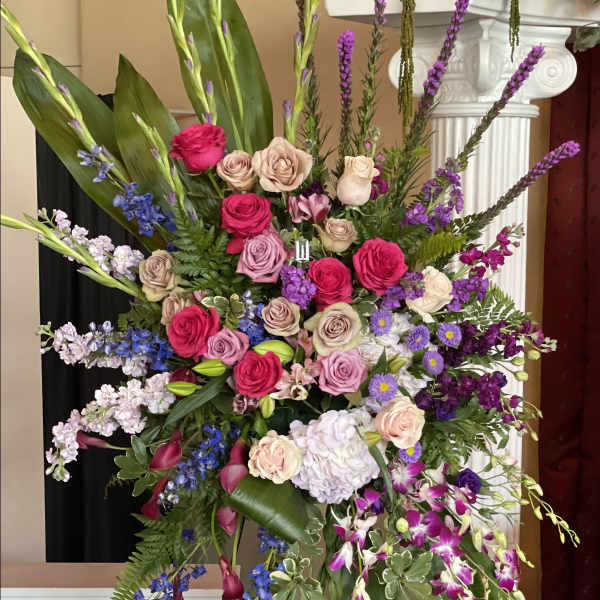 Large standing floral spray with pink, purple, and white blooms