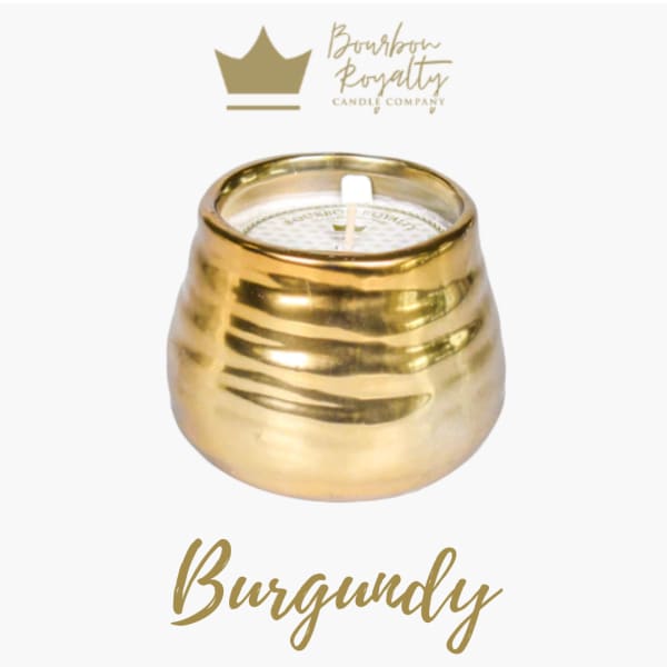 Gold candle in a rounded metallic holder with a white wick