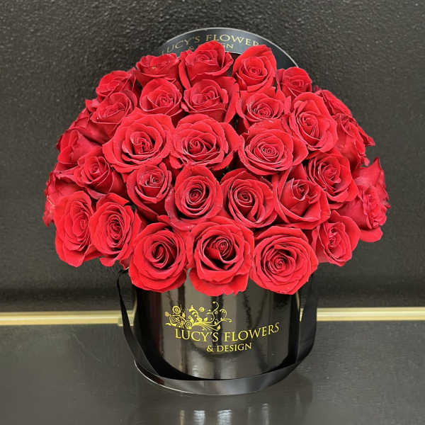 Red roses arranged in a black round box
