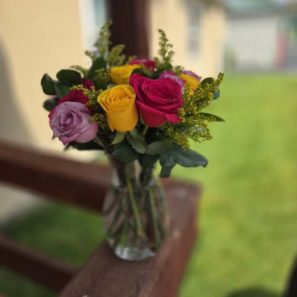 Bouquet of multicolored roses in a clear glass vase