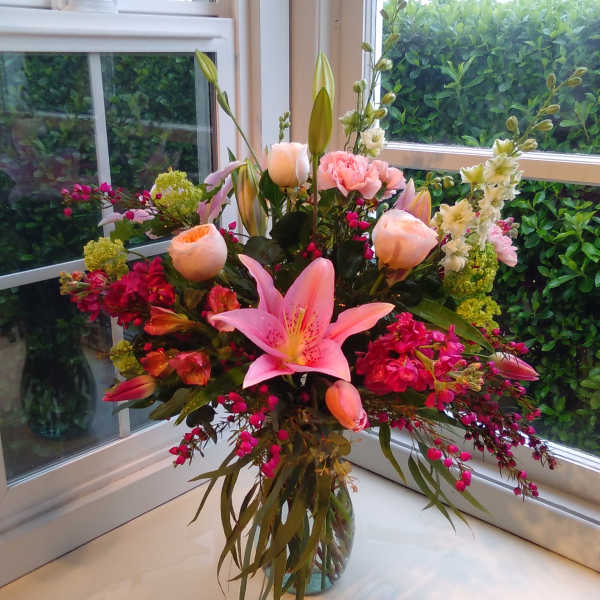 Pink lily and rose bouquet in a glass vase