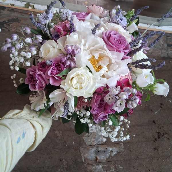 Handheld bouquet of pink and white flowers with lavender accents
