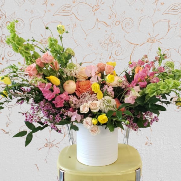 Colorful mixed flower arrangement in a white vase