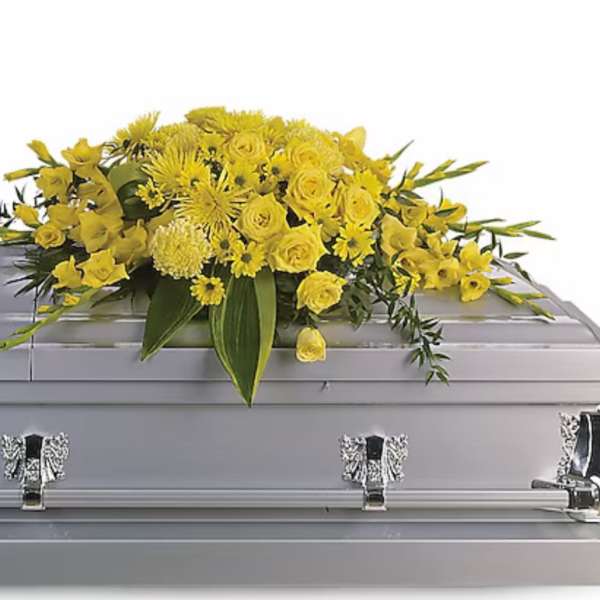Yellow floral spray arranged on a silver casket