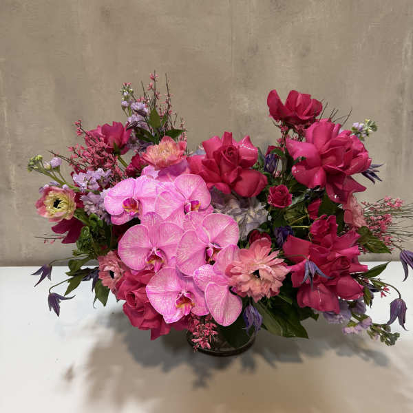 Pink and purple floral arrangement in a low vase
