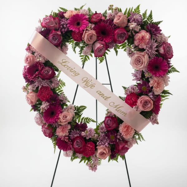 Heart-shaped floral wreath with pink and purple flowers and a ribbon