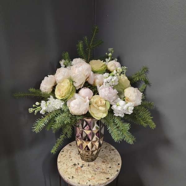 Blush and cream flower arrangement in a faceted metallic vase