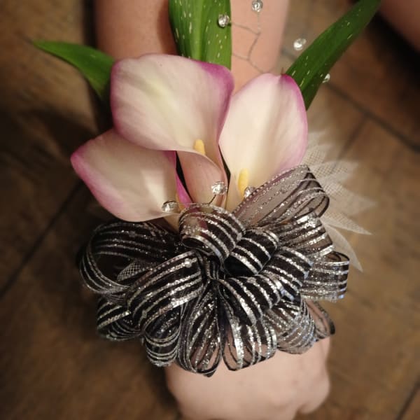 Pink-and-white calla lily corsage with a black-and-silver ribbon bow
