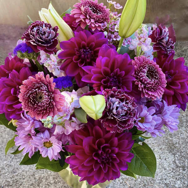 Bouquet of magenta and lavender flowers in a clear glass vase