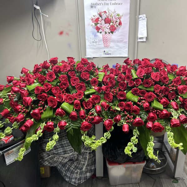 Large arrangement of red roses with green accents on a table