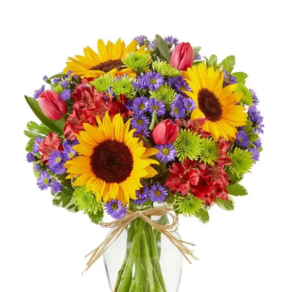 Bouquet of sunflowers, tulips, and mixed blooms in a glass vase