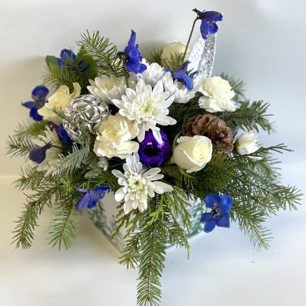 White and blue floral arrangement with pine branches and ornaments