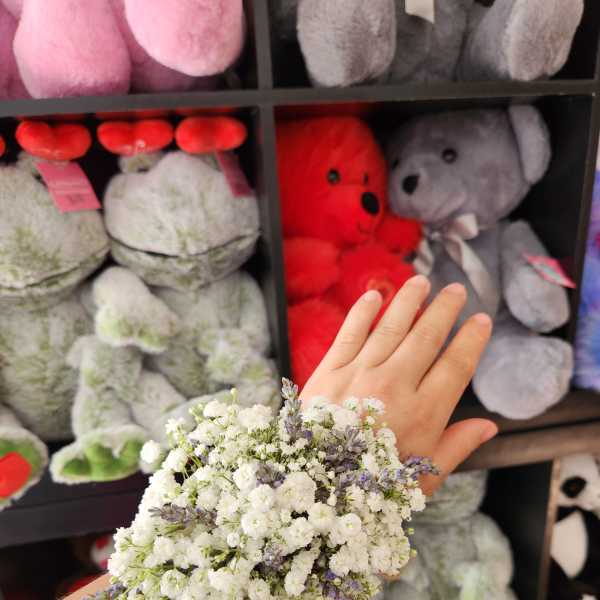 Small white and lavender flower cluster held on a wrist