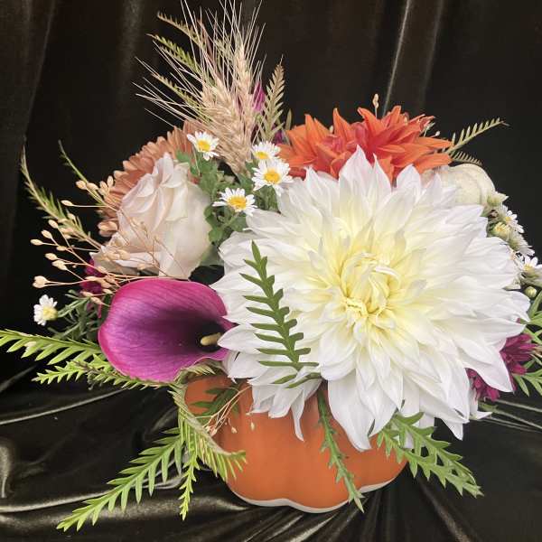 Mixed floral arrangement in an orange pumpkin-shaped container