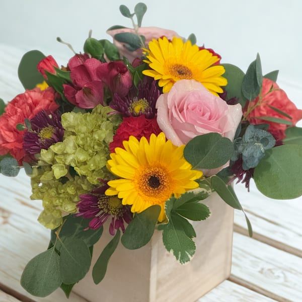Mixed bouquet in a square wooden box with pink roses and yellow daisies