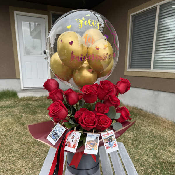 Red roses with a clear balloon and gold balloons on top