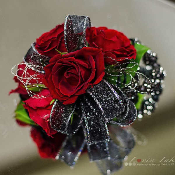Small bouquet of red roses with black ribbon and silver accents