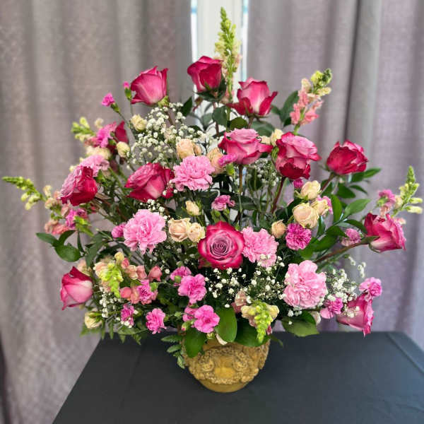 Pink roses and carnations arranged in a gold vase