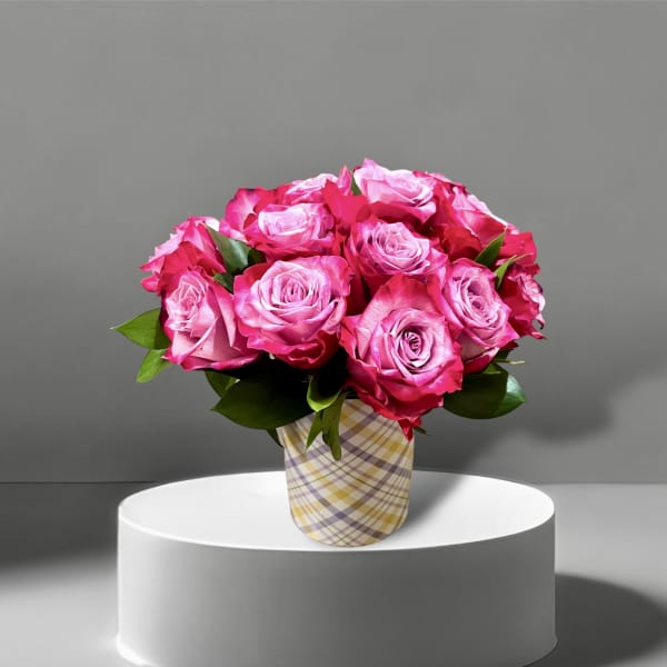 Pink roses arranged in a plaid paper-wrapped vase