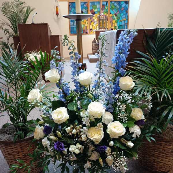 Large white and blue floral arrangement in a white vase