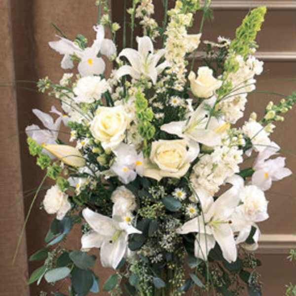 Tall white floral arrangement in a clear glass vase