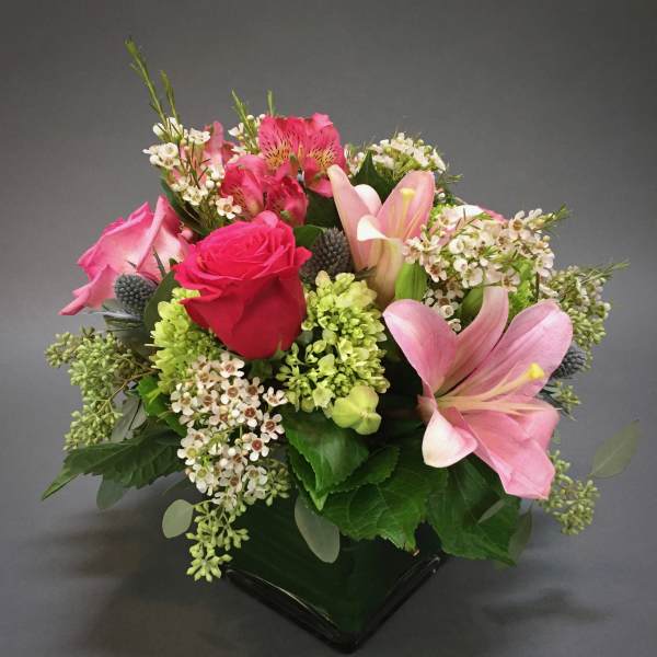 Pink and red mixed flower bouquet in a black vase