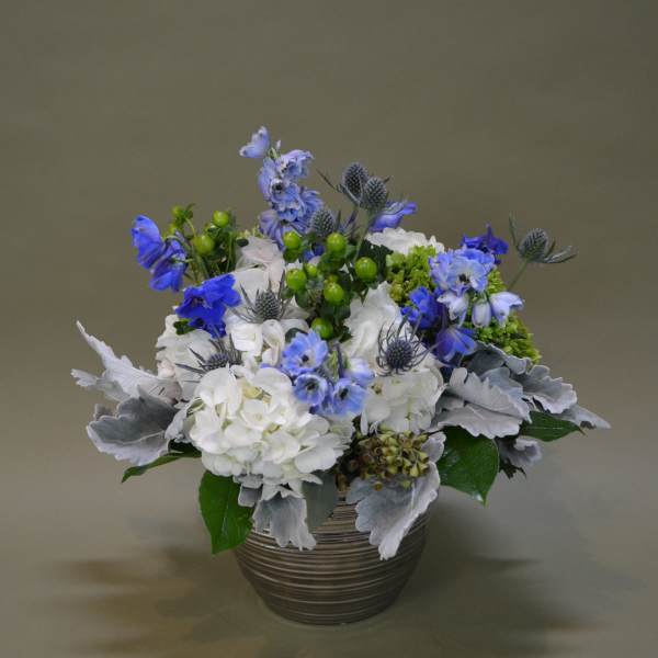 Blue and white floral arrangement in a ribbed metal pot