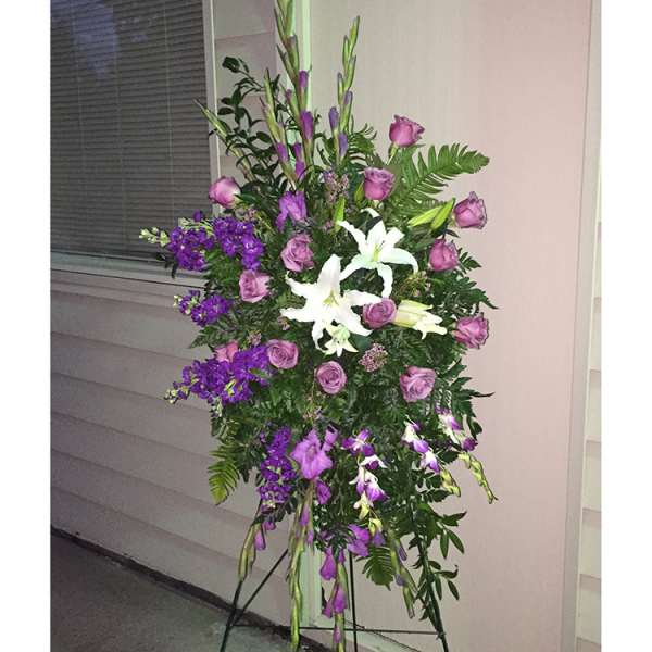 Tall standing floral spray with purple roses and white lilies