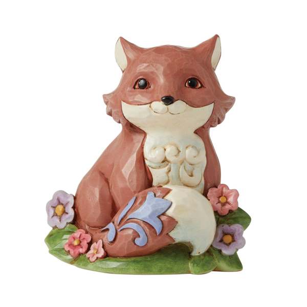 Painted fox figurine sitting among small flowers