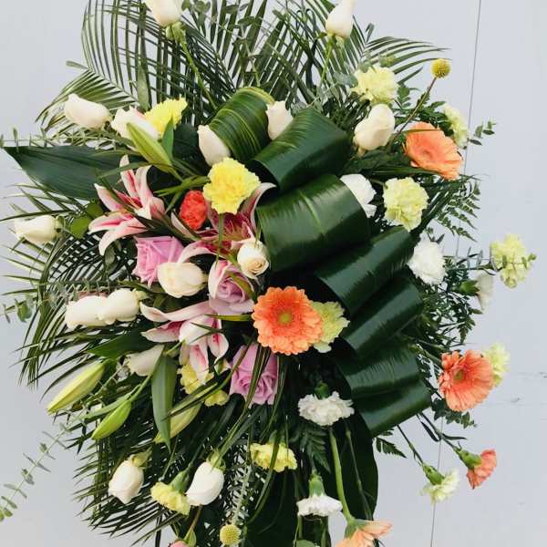 Large standing floral spray with white lilies, roses, and gerbera daisies