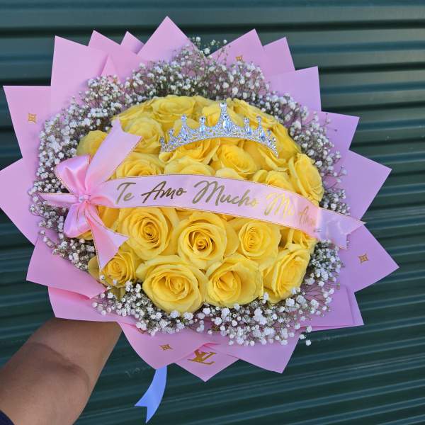 Yellow rose bouquet with pink wrapping and a small crown topper