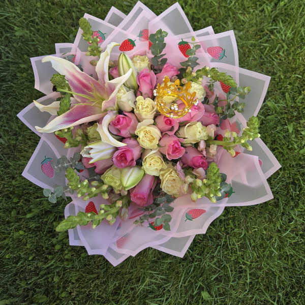 Pink and cream rose bouquet with lilies in strawberry-patterned wrap