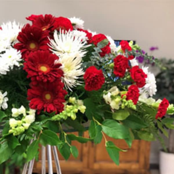 Large red and white floral spray on a stand