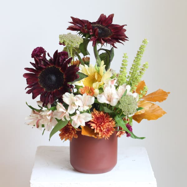 Mixed bouquet in a matte vase with burgundy sunflowers and white alstroemeria
