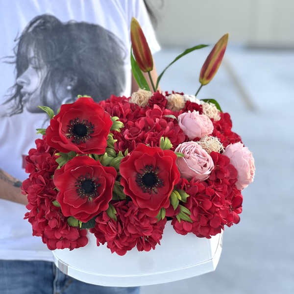 Red and pink flower arrangement in a white box