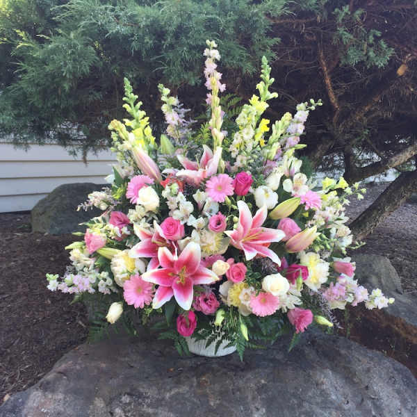 Large pink and white floral arrangement in a white basket