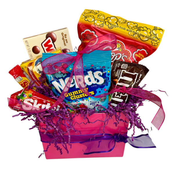 Pink gift box filled with assorted candy bags and boxes with purple paper shred and ribbons
