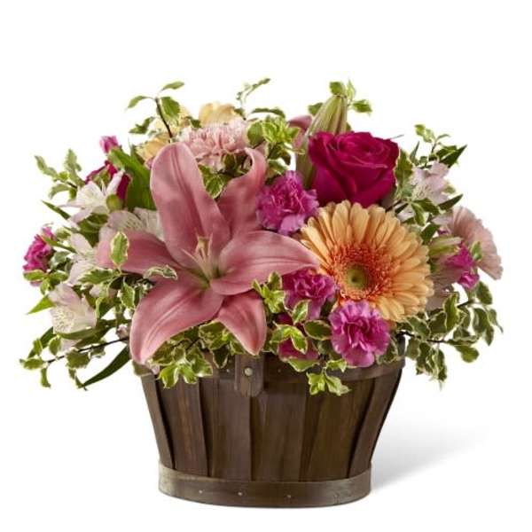 Mixed pink and peach flowers in a wooden basket