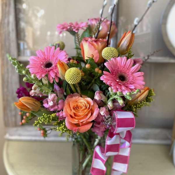 Pink and peach mixed flower bouquet with a striped ribbon