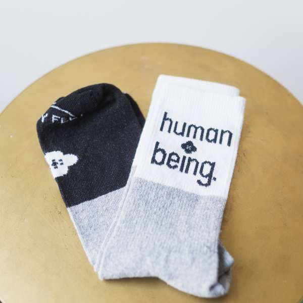Pair of black and white socks with text on a round surface