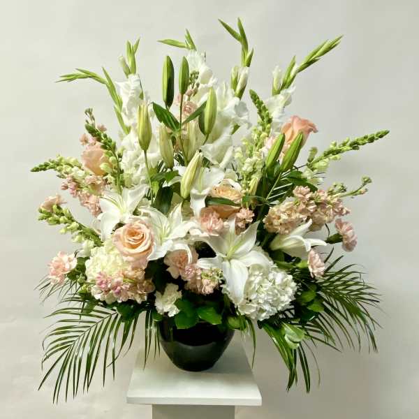 White lilies and pale pink roses in a black vase