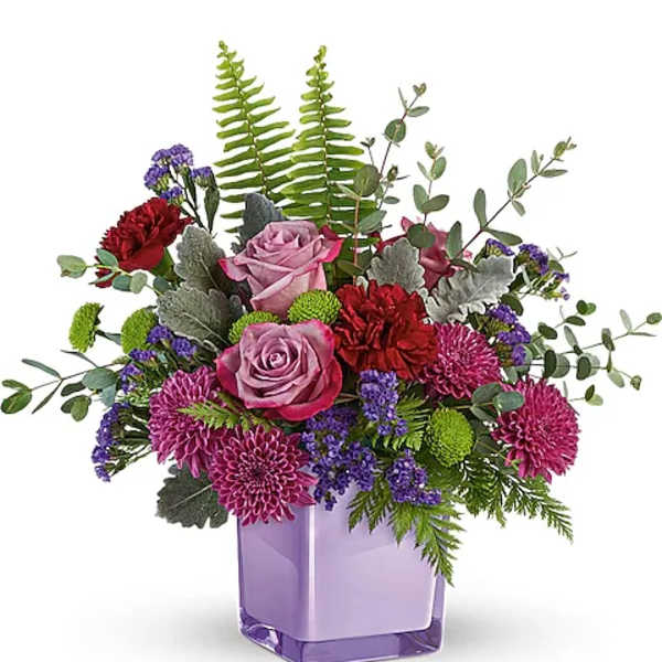 Purple and pink floral arrangement in a lavender glass vase