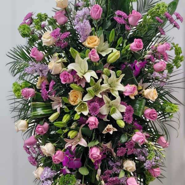 Large standing floral spray with pink and cream roses and lilies